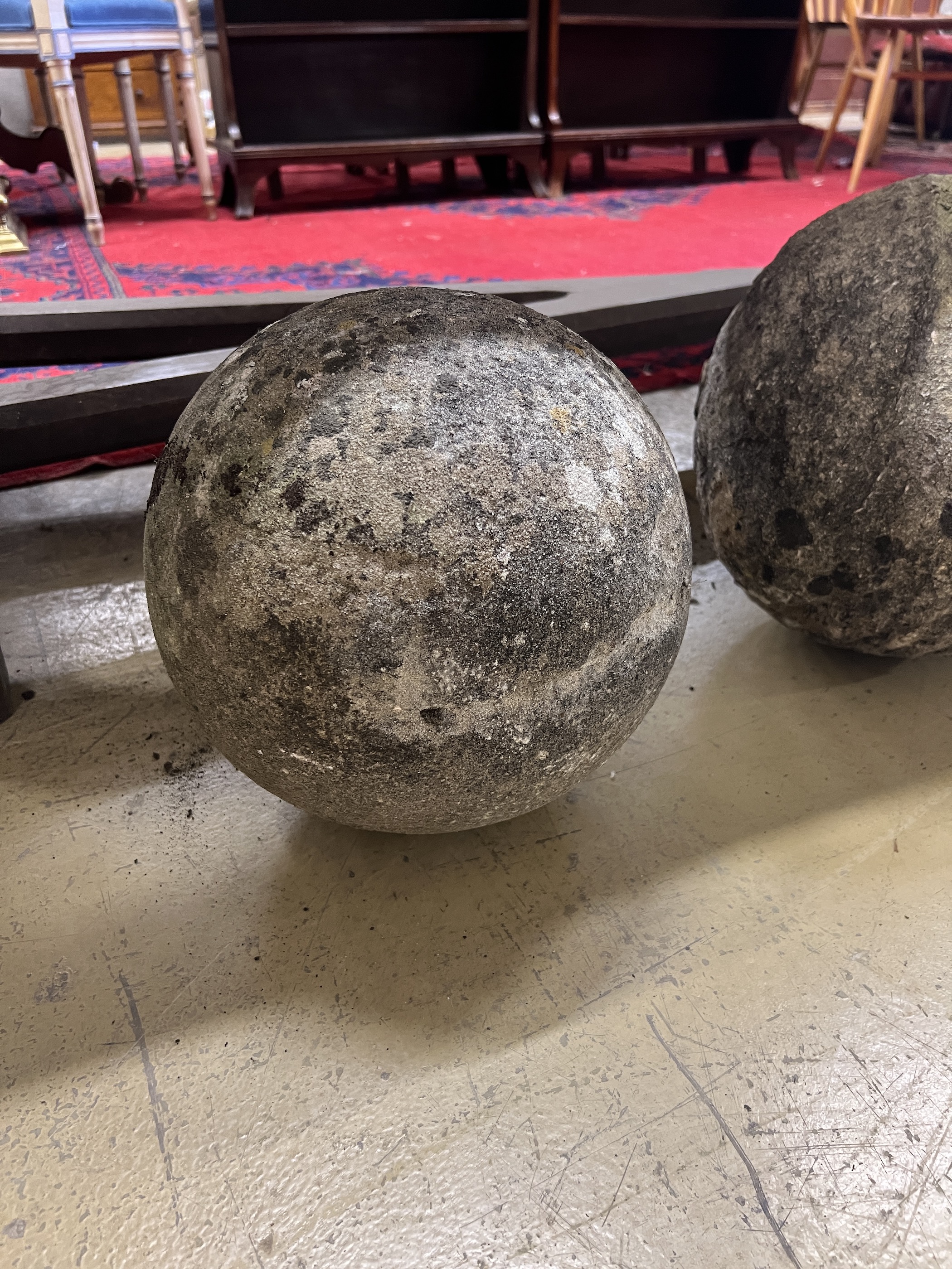 A trio of graduated reconstituted weathered stone ball finials, largest height 37cm
